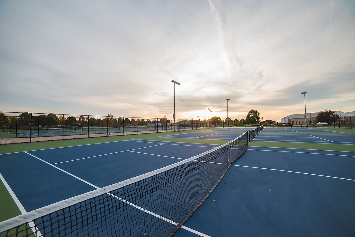 A picture of the sun setting over the tennis courts at Heritage Park where the boys tennis team plays